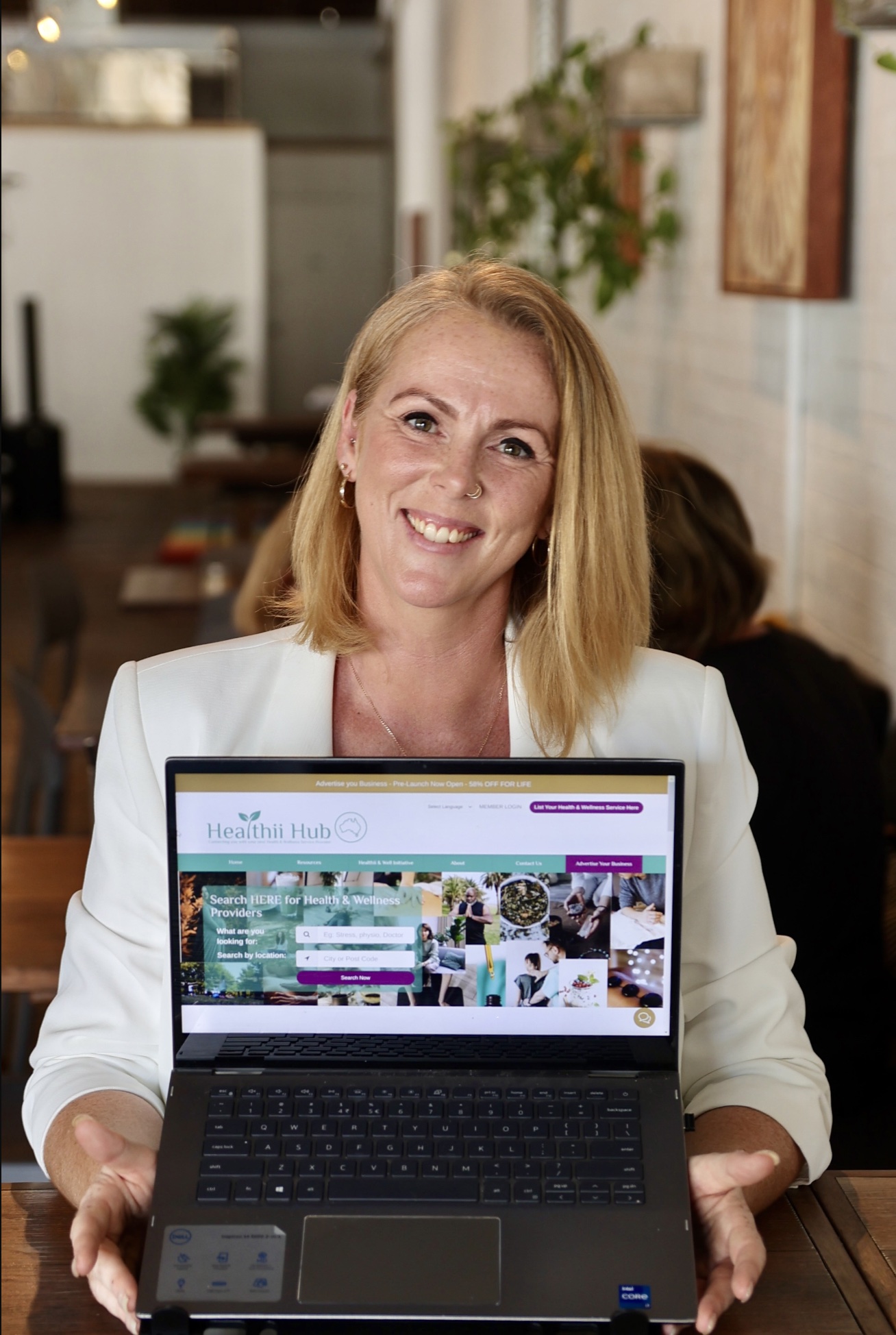 Sara Millar - Founder of Healthii Hup, holding a laptop with the screen open to the Healthii Hub Home Screen